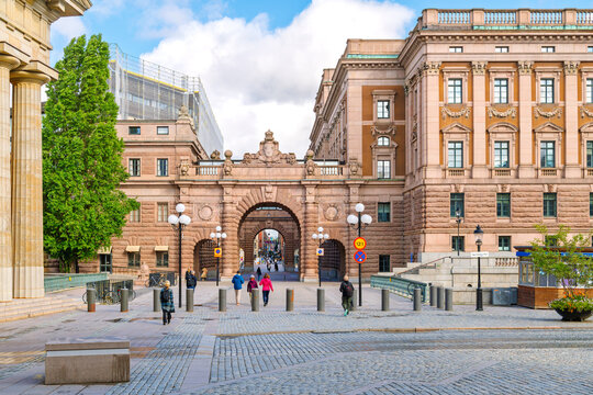 Pedestrians enter the arched entrance to Riksgaten shopping street from the Riksdag building which houses the Swedish Parliament in Gamla Stan old town, Stockholm, Sweden.