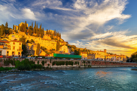 Golden hour sunset from the Adige River Ponte Pietra stone bridge looking towards Castel San Pietro in the historic city of Verona, Italy.