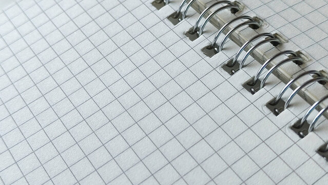 Professional spiral bound notebook with white grid paper and silver wire binding close up