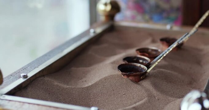 Brewing Turkish coffee in hot sand using traditional cezve method