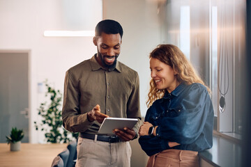 Happy diverse entrepreneurs working digital tablet in office.