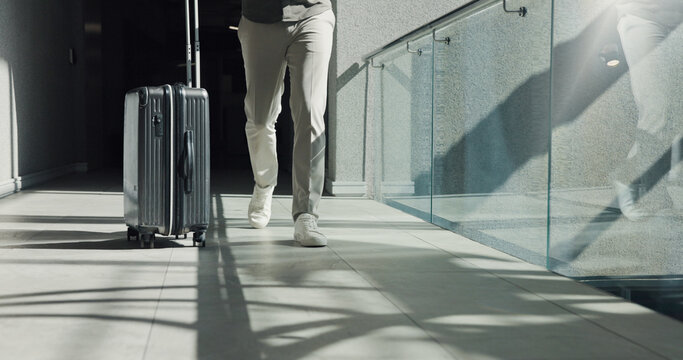 Business person, legs and walking with suitcase for travel, work commute or job opportunity. Traveler, employee or moving with luggage for company trip, schedule flight or career journey in building