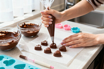 キッチンでハート型チョコレートにデコレーションを施す、バレンタインスイーツ作り