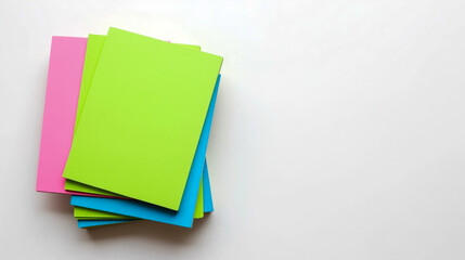 a stack of colorful paper notes on a white surface. The notes are arranged in a layered fashion. The top note is bright green