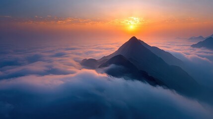 Mountain peak rises above clouds at sunrise in a clear sky