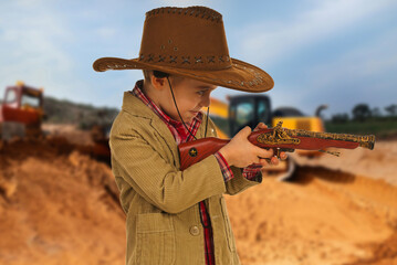A young boy in a cowboy hat and jacket holding a toy gun