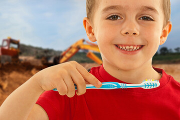 A young boy is brushing his teeth with a blue and white toothbrush