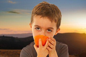 A boy is eating an orange