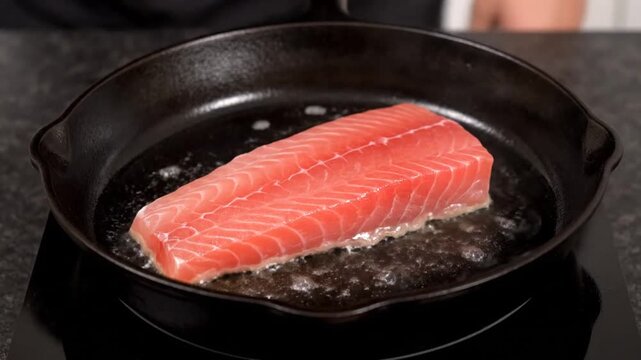 A person skillfully sears a fresh salmon fillet in a cast-iron skillet, showcasing the cooking process with steam rising, set in a modern kitchen environment