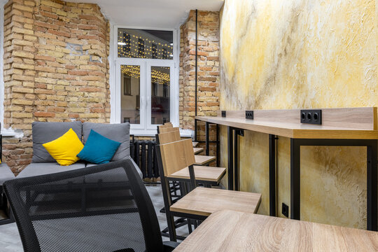 Night view of a hostel coworking zone with bar stools and city lights