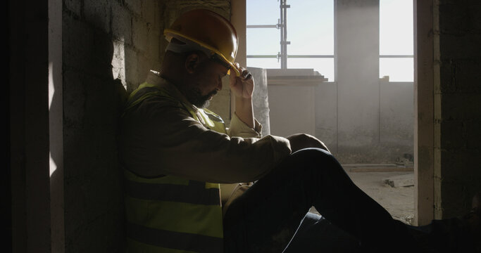 Construction site, thinking or man with safety, sad or overwhelmed with maintenance. Break, person or inspection with urban development, delay or engineer with fatigue or pressure to finish project