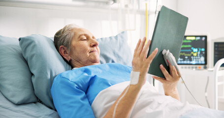 Senior woman, sick and tablet in hospital bed, scroll and streaming service for recovery, movie or...