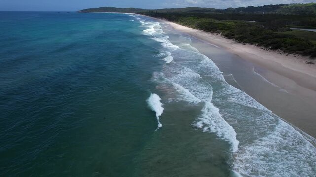 Waves Crashing Against The Sandy Stretch Of Tallow Beach In Byron Bay, NSW, Australia. - aerial shot