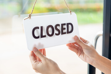 Turns the sign from closed to open welcoming customers to a new cafe and small business restaurant in the morning. New business coffee shop cafe. Happy Owner or waitress in apron