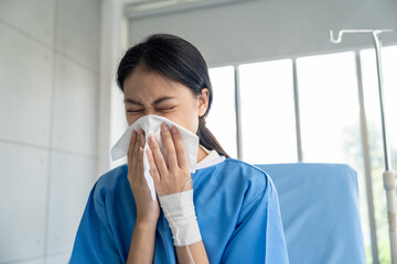 Sick woman patient on hospital bed with fever, cough, and sore throat, feeling tired and lonely...