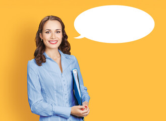 Portrait image of happy smile young business woman businesswoman wear blue shirt with folder. White empty mockup speech bubble. Happy cute girl isolated orange yellow background