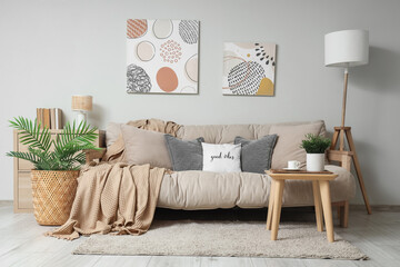 Comfortable sofa with coffee table, floor lamp and picture in interior of living room