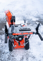 close up on snow blower removing snow on the driveway