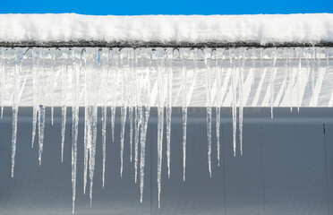 winter house with icicle and snow on the roof