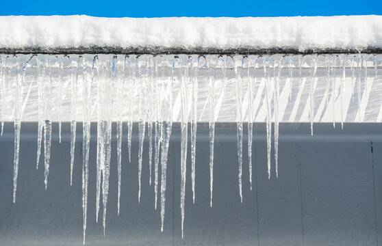 winter house with icicle and snow on the roof