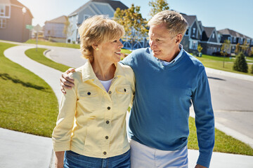 Naklejka premium Love, senior couple and walking in neighborhood for fresh air, bonding together or retirement support. Happy, elderly people and hug with romantic stroll outdoor for connection, wellness or affection