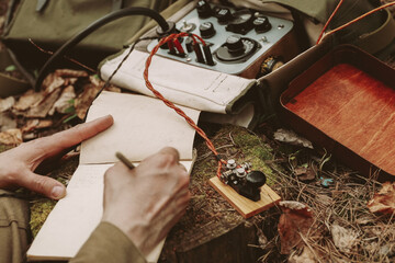 Russian Soviet Infantry Red Army Soldier In World War II using Russian Soviet Portable Radio Transceiver In Trench Entrenchment In Spring Autumn Forest. 4K. Headphones And Telegraph Key. Close Up © Great Brut Here