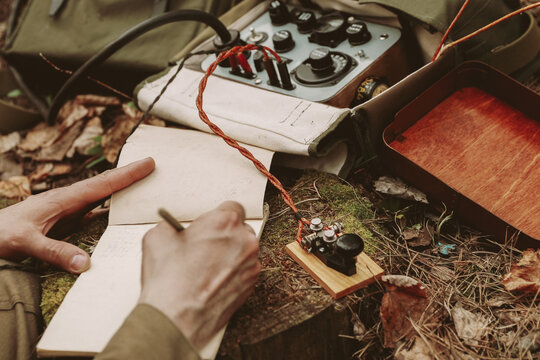 Russian Soviet Infantry Red Army Soldier In World War II using Russian Soviet Portable Radio Transceiver In Trench Entrenchment In Spring Autumn Forest. 4K. Headphones And Telegraph Key. Close Up