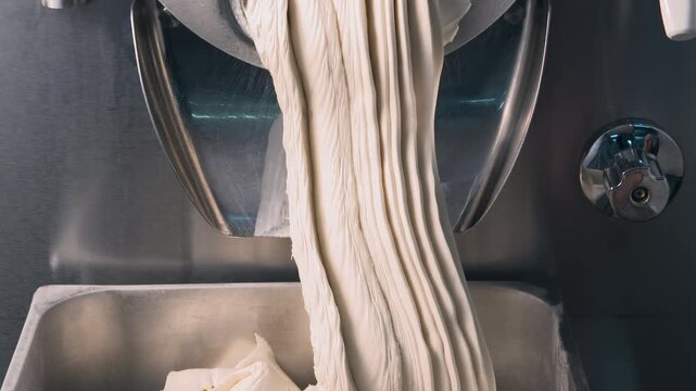 Finished gelato exiting the machine in a quick-paced shot, highlighting the smooth texture and bulk manufacturing of premium desserts