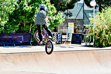 Obraz premium A young man practicing BMX and performing tricks at the skatepark.