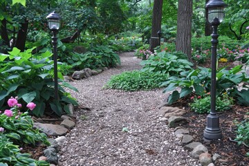 A serene garden path lined with lush greenery and blooming flowers, creating a peaceful and inviting atmosphere.