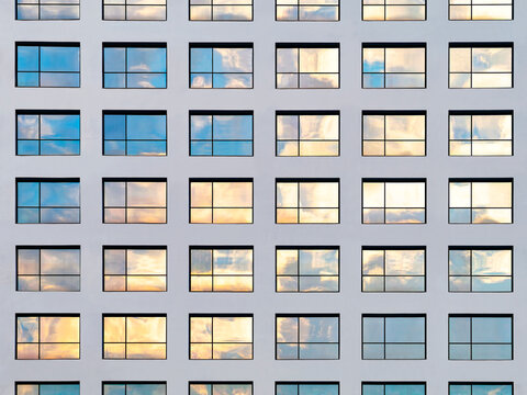 Window frame pattern reflecting  Cloudy sky sunset geometric grid Modern building exterior Architecture details 