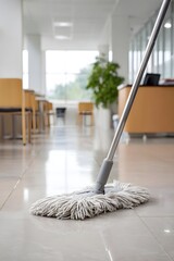 Mop cleaning a shiny tiled floor in an office