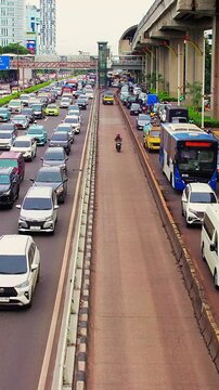 Timelapse of Traffic condition on Gatot Subroto street Jakarta during rush hour with camera movement from left to right, portrait video.