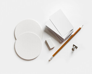 Blank stationery set. Blank business cards, coasters, pencil, eraser on paper surface.