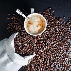 Coffee cup and coffee beans in a canvas bag. Flat lay.