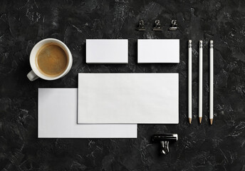 Blank corporate stationery set on black plaster surface. Mockup for design presentations and portfolios. Flat lay.