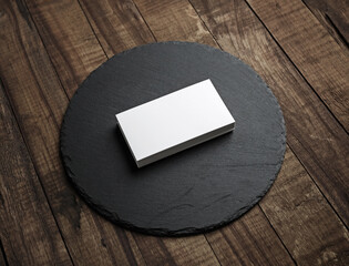 Blank business cards stack and round slate plate on wooden surface. Branding ID mockup.