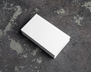 Stack of blank white business cards on concrete surface. Branding mock up.