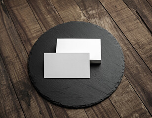 Blank white business cards on wooden surface. For design presentations and portfolios.