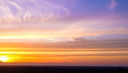 Fototapeta premium Fiery sunset hues paint the sky above a distant, dark horizon