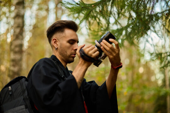 Person uses camera in forest during daytime