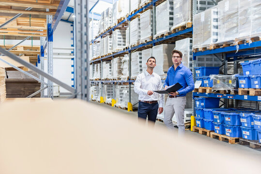 Business meeting in production hall warehouse with managers
