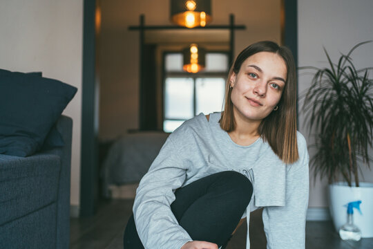 Young woman relaxing at home looking at camera in cozy living room