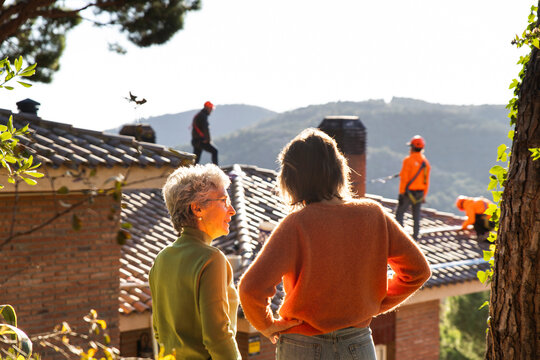 Homeowners observing solar panel installation on house roof in Barcelona