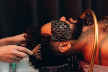 Man enjoying head spa treatment with jade eye mask © Roman