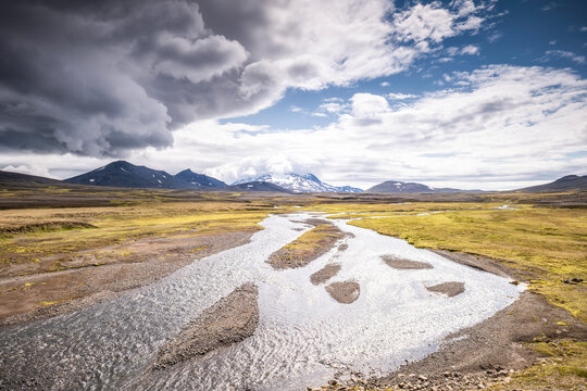 Braided river flows through Icelandic volcanic tundra toward Mount Sn�fell
