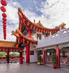Fototapeta premium Thean Hou Temple, Kuala Lumpur, Malaysia, showcasing vibrant red lanterns, ornate traditional Chinese architecture, and a white balustrade under a blue sky