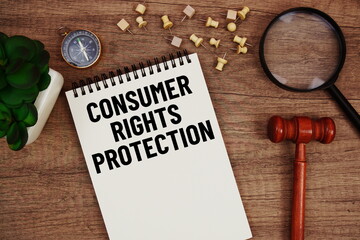 Consumer Rights Protection message written on notepad with wood gavel and magnifying glass flat lay on wooden background