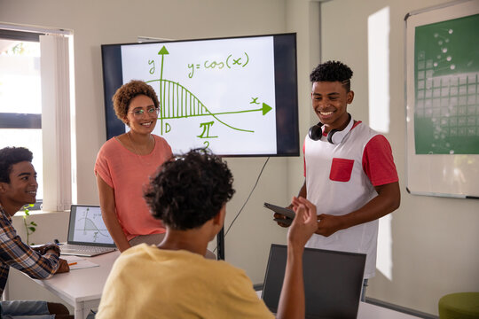 African american male student presenting cosine graph on screen tv in math classroom