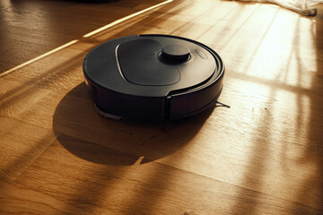 Robot Vacuum Cleaner Operates on Hardwood Floor in Bright Room During Daytime